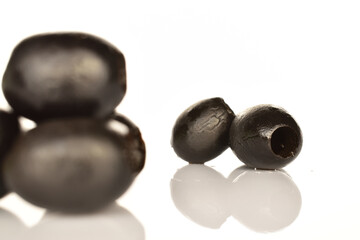Pickled spicy black olives, close-up, on a white background.