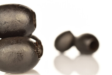 Pickled spicy black olives, close-up, on a white background.