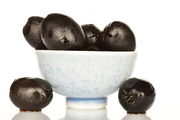 Pickled spicy black olives, close-up, on a white background.