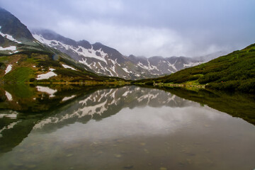 Fototapeta na wymiar Mountains lakes. Valley of the five ponds in the Tatras. Rainy day. Shooting with raindrops.