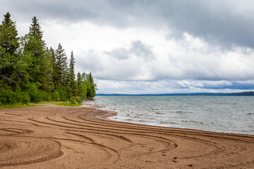 The sandy shore of Clear Lake in Wasagaming, Manitoba on a cloudy day
