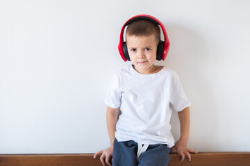 Boy in white t-shirt with headphones isolated on white background