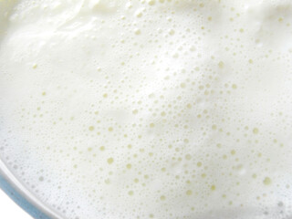 Boiled milk in a glass cup on a white background. Isolated