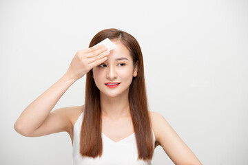 Fototapeta premium Close up of beautiful happy Asian woman using oil absorbing sheets, beauty concept.