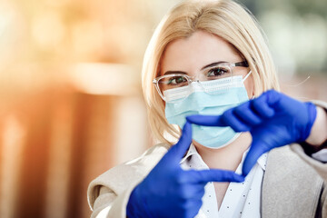 woman wearing medical mask and gloves making hand  gesture