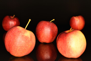 Red ripe apples, close-up, on a black background.