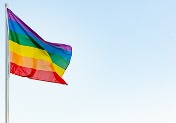lgbti concept: lgbt rainbow flag on a pole waving in the wind