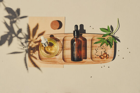 CBD oil, tincture with a pipette on a beige background with hemp leaves. Concept medical cannabis Trendy Flat Lay Minimalism