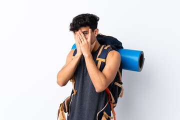 Young Argentinian hiker man over isolated white background covering eyes and looking through fingers