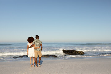 Fototapeta na wymiar Mixed race couple holding each other on the beach