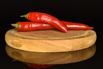 Red chili peppers, close-up, on a black background.