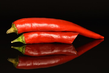 Red chili peppers, close-up, on a black background.