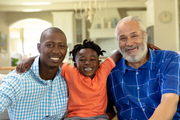 Man at home in the living room sitting with his son and father