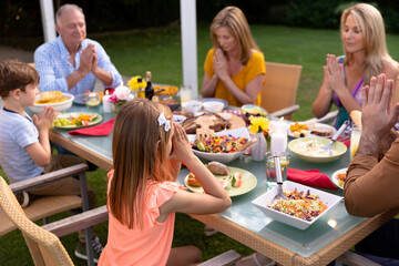 Caucasian family saying grace together before eating - Powered by Adobe