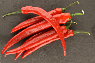 Red chili peppers, close-up, on a serving plate of slate.