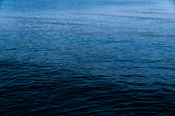 Background of a calm blue sea with the texture of the waves in the blue hour at sundown. Concept of climate crisis and refugee crisis in the Mediterranean Sea.