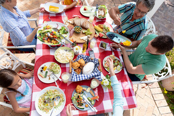Caucasian family sitting at table during a family lunch in the garden