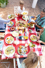 Caucasian family sitting at table during a family lunch in the garden