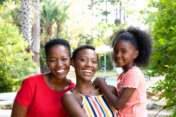 Senior African American woman spending time with her daughter and her granddaughter in the garden 