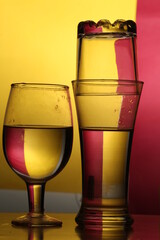 glass of wine and bottle with red and yellow background 