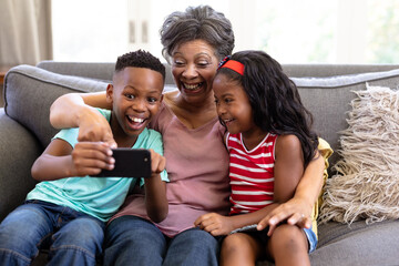 Senior mixed race woman and her grandchildren at home