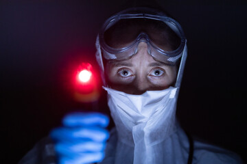 Healthcare worker holding gun thermometer and wearing coronavirus Covid19 mask
