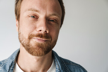 Obraz premium Photo of joyful young man with red hair posing and smiling on camera