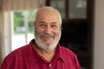 Senior man smiling at camera at home