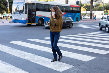 Caucasian woman wearing a protective mask and coughing out in the streets