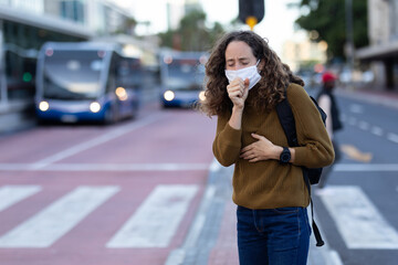 Caucasian woman wearing a protective mask and coughing out in the streets
