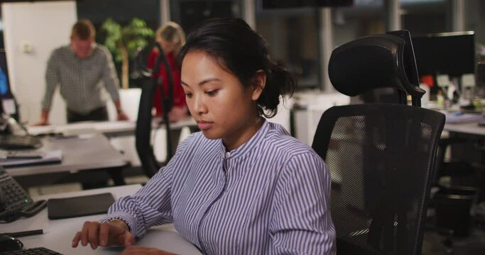 Professional businesswoman using computer while sitting on her desk in modern office in slow motion