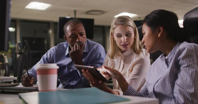 Professional business people discussing over a digital tablet in modern office in slow motion