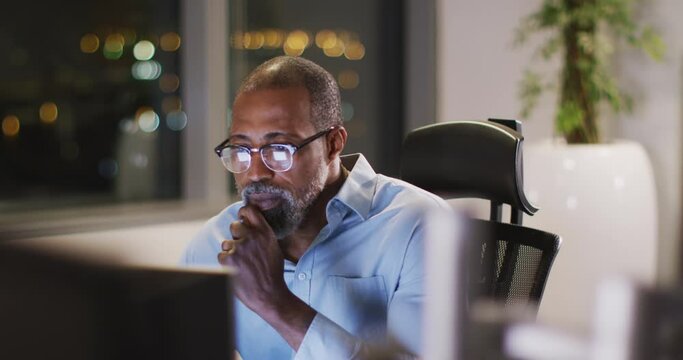 Professional businessman working while sitting on his desk in modern office in slow motion
