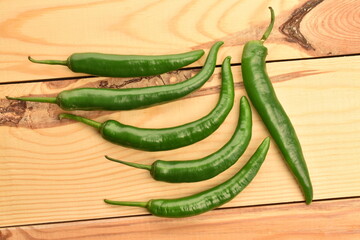 Green chili pepper in a cut, close-up, on a  wooden table.