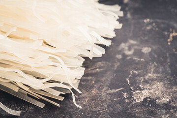 Raw rice noodles on the black rustic background. Selective focus. Shallow depth of field.
