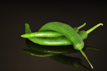 Green chili pepper, close-up, on a black background.