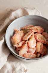 Frozen shrimps on gray plate close-up.Natural seafood ingredient for cooking.Vertical orientation