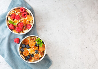 Pancakes with blueberries, raspberries, mint and honey for a breakfast, top view