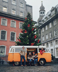 Group of young friends traveling by Vintage Camper. .Rothenburg ob der Tauber, Christmas decorated city of Franconia, Bavaria in Germany. People lifestyle transportation travel