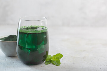 Green drink prepared with single celled green algae chlorella. Detox superfood in the glass with...