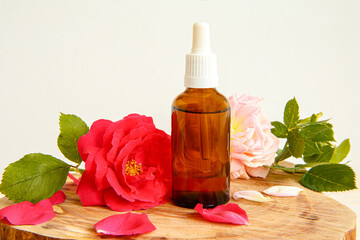 Rose and bottle with aromatic oil or medicine on a stand made of wood
