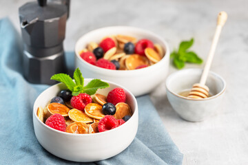 Tiny cereal small pancakes with blueberries, raspberries, mint and honey for a breakfast