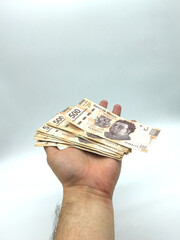 Mexican pesos bills in hand