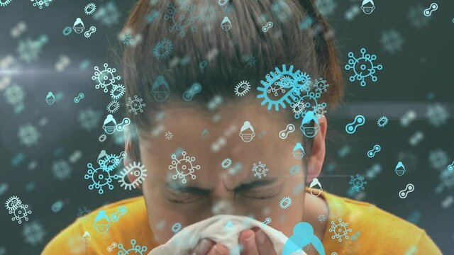 Animation of macro Covid-19 cells icons floating over Caucasian woman sneezing into tissue in slow m