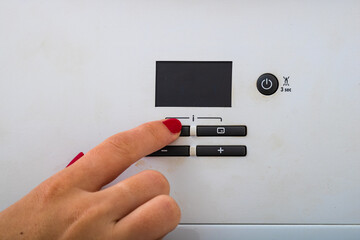 Woman hand try to turn off and on the central heating in the room. Female hands on the central...