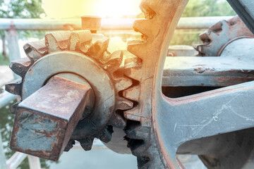Close up large gears of the floodgate are mounted on an outdoor concrete base, used to control the opening and closing of the floodgate of a dam, reservoir or large waterway.