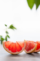 Juicy grapefruit slices with green leafs on white background. Side view, close up, copy space. healthy food, nutrition, dieting. Natural cosmetics