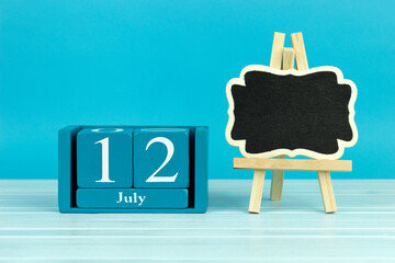 wooden calendar with the date of June 12 and an easel on a blue background, place for text, World Flight Stewards Day, Scandinavian Fjord Day
