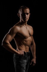 Fototapeta premium Muscular young man in a studio. Portrait of strong brutal guy naked torso.