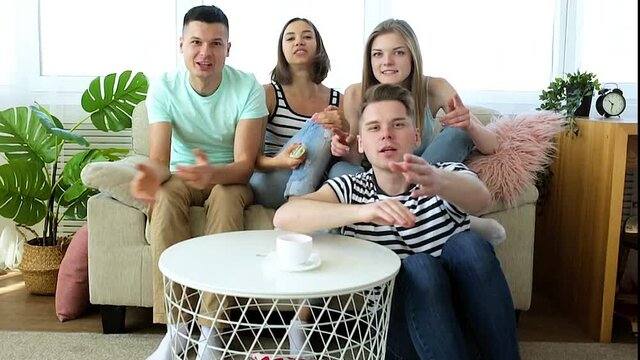 Fans watching the game. Group of young emotional people watching tv. Friends having fun together.